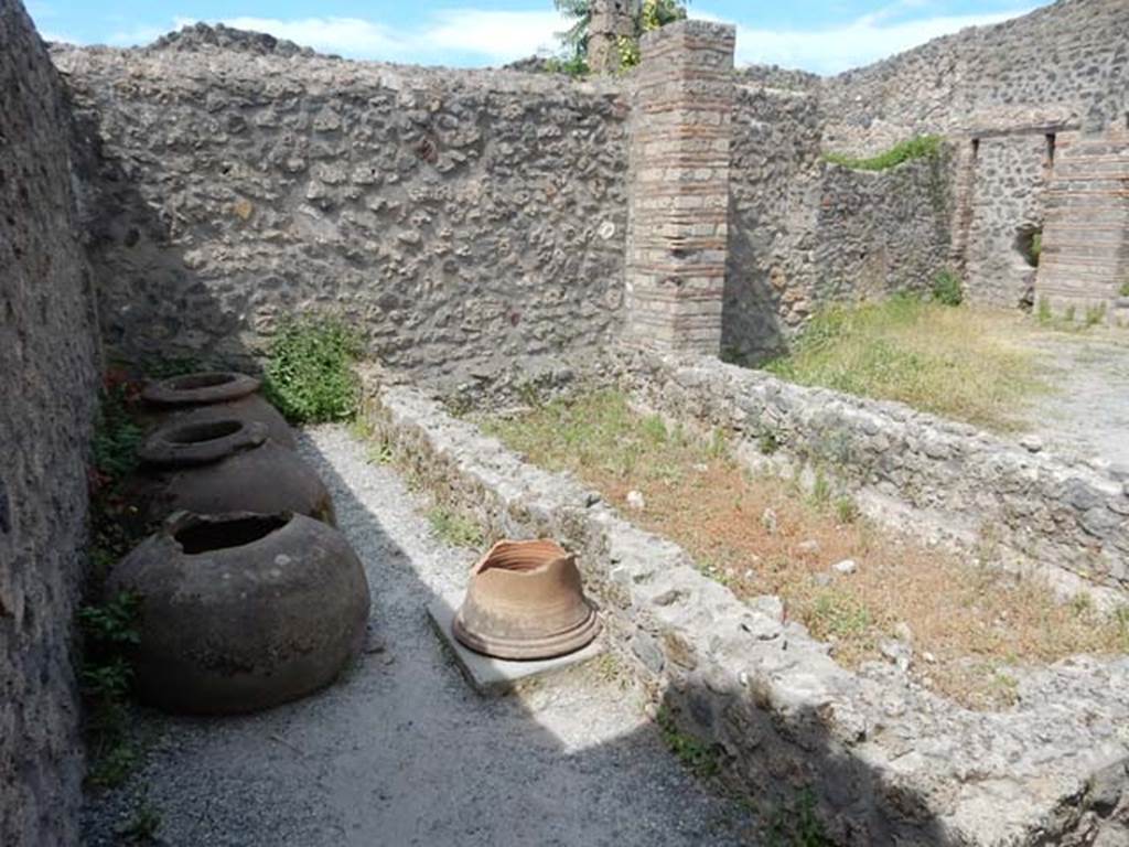 I.21.2 Pompeii. May 2017. Looking towards west wall, dolia and puteal.  Photo courtesy of Buzz Ferebee.

 
