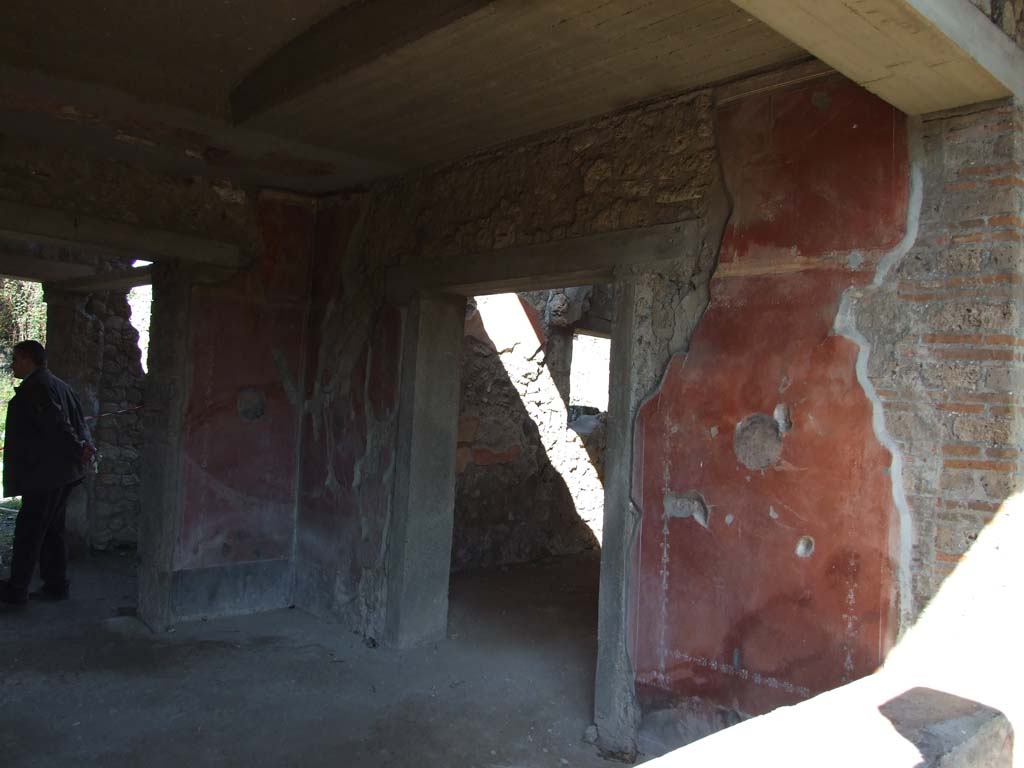 V.3.4 Pompeii. March 2009. East wall of tablinum, painted with large red panels with a medallion in their centres.