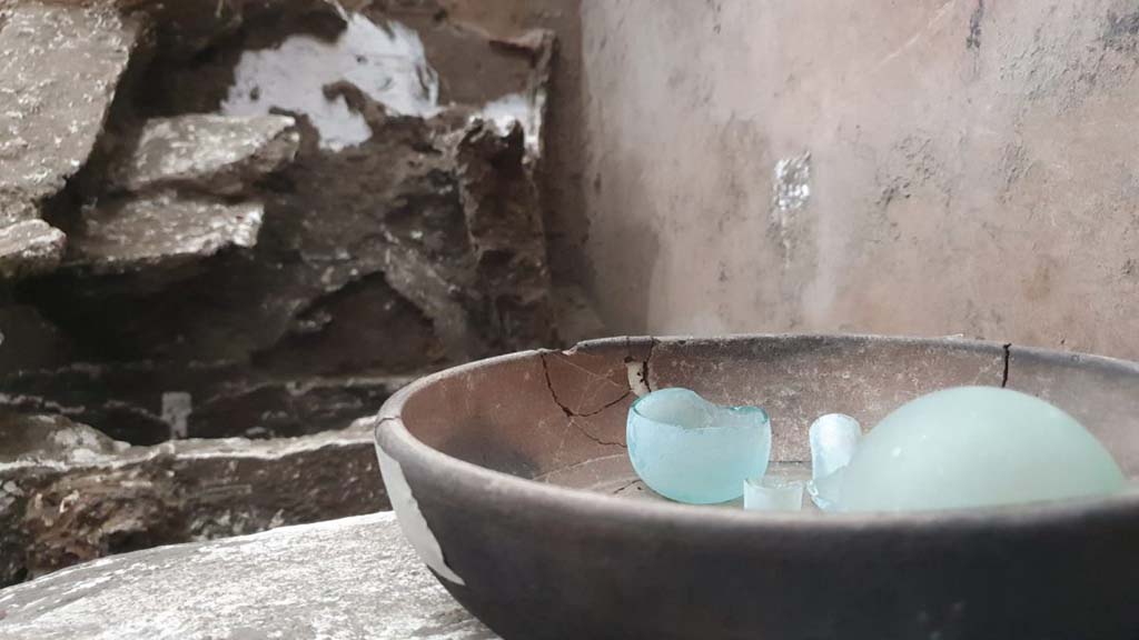 V.3.13 Pompeii. 2022. Room 3b, bedroom.
Ceramic cup containing two glass ampoules.
Una coppa in ceramica contenente due ampolline in vetro.
Photograph © Parco Archeologico di Pompei.

