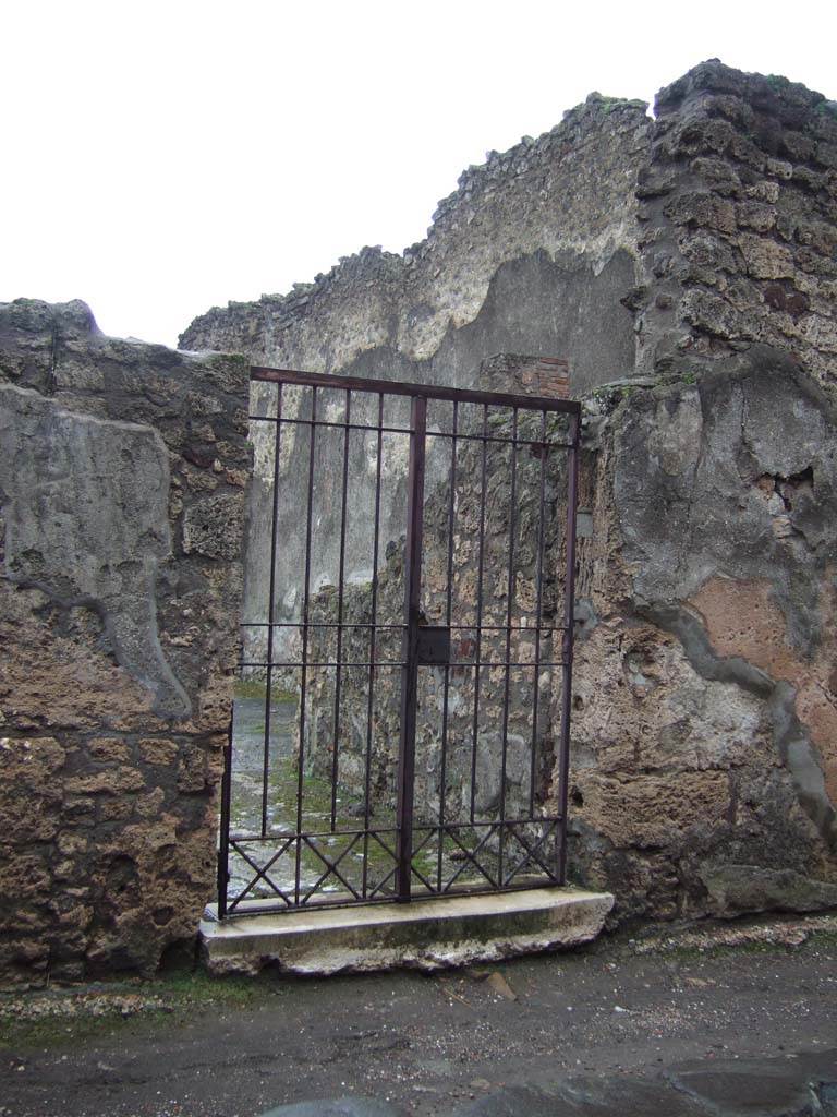 VI.14.39 Pompeii. December 2005. Entrance doorway leading into fauces/entrance corridor.
The fauces or entrance corridor had a threshold of marble, and the doorway would have been closed with two door-shutters.
According to Mau, it seemed that the shutter on the left would have remained closed, as only on the right did he see the circle that attached and closed the door with the bolt. 
The flooring was made up of irregular pieces of marble and was interrupted by a strip that was intended to carry away the rainwater from the impluvium to the street. 
This strip was formed of opus Signinum with a few pieces of marble and resembled the flooring of the atrium (opus Signinum with crushed lava), but from which it was distinguishable.
See Mau in Bullettino dell’Instituto di Corrispondenza Archeologica (DAIR), 1878, (p.89)
