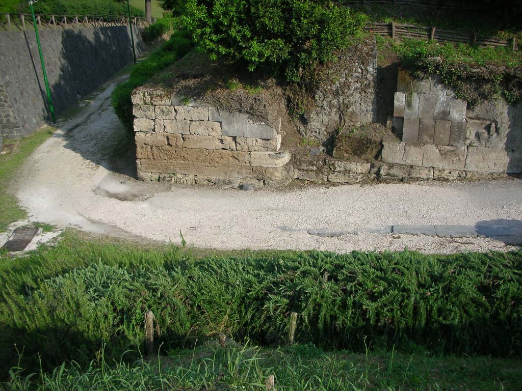 Porta di Sarno or Sarnus Gate. May 2010. Interior south wall of gate at east end. Photo courtesy of Ivo van der Graaff.
According to Van der Graaff –
“The southern side is in a somewhat better state [than the north side]. The outer bastion is heavily damaged, rising to a maximum of six courses.
Its rear half features a series of tuff courses, which, due to the tool marks and very good state of preservation must be modern.
They resemble similar blocks applied as restorations on the adjacent curtain wall. The gate court features large tuff orthostats on top of a foundation composed of travertine ashlars. Occasional crowbar marks suggest that workers removed some of the original masonry for reuse elsewhere (Note 71).
A lowering of the roadway that occurred in the Augustan period led to the exposure of the foundations visible today.
A number of tuff blocks are inserted headfirst into the agger: given their similarity with the blocks on the outer bastion, these must also represent a modern reconstruction. Their different orientation probably represents an effort to highlight the restoration.” 
See Van der Graaff, I. (2018). The Fortifications of Pompeii and Ancient Italy. Routledge, (p.62, and Note 71).
