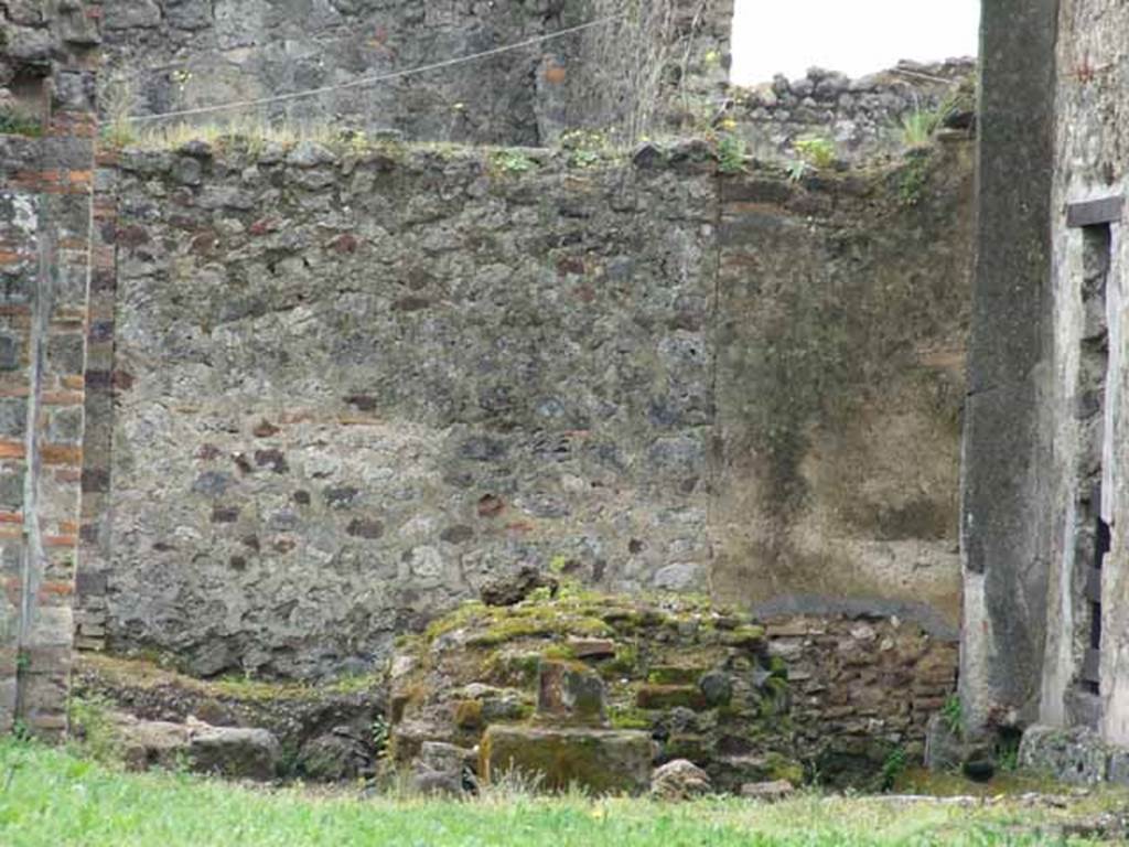 VII.6.3 Pompeii. May 2010. Remains of the large and elegant shrine in the south part of viridarium 18. The altar on its north side can be seen. According to Boyce, the sacrarium was found in a small room opening off the south side of the peristyle, only the solid podium remains. The podium was coated with grey stucco on its sides and paved on top with pounded sherds. In front of the base stood the remains of a small altar of tufa in the form of a rectangular pillar upon a base; the whole covered with red stucco. See Boyce G. K., 1937. Corpus of the Lararia of Pompeii. Rome: MAAR 14. (p. 67, no.286).