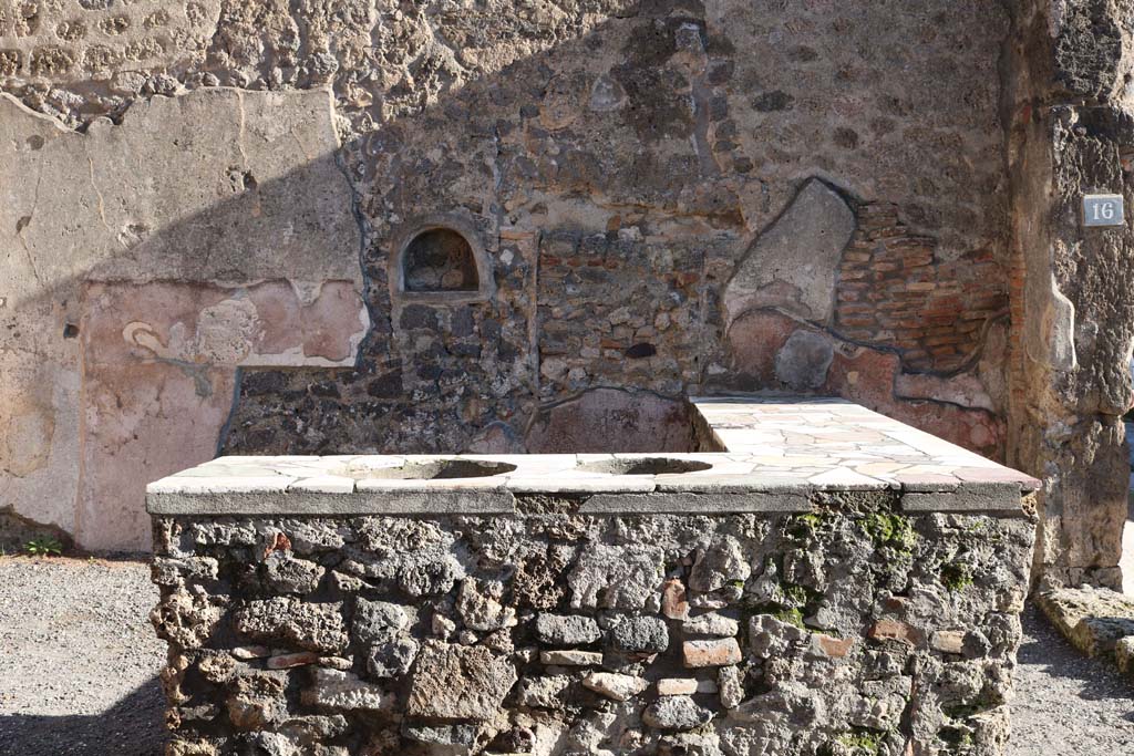 IX.1.16 Pompeii. September 2018. Looking east across counter towards wall with niche. Photo courtesy of Aude Durand.