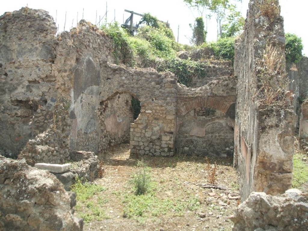 IX.6.7 Pompeii. May 2005. 
Looking south from entrance doorway, into large kitchen (room “p” on plan) with remains of hearth (on left of entrance doorway under the window), a tub/basin against the east wall and doorway to room “s” on east side of peristyle of IX.6.5.  According to Mau, the entrance doorway (at IX.6.7) was originally 2,11 wide so he assumed that here, at one time, some industry was done, but that it was later narrowed to 1.06. In the last times of the house, "p" was the kitchen with hearth leaning against the north wall, and above it was a square window.  Against the east wall, a tub/basin was leaning (2.24 x 0.76 measured externally, and 0,65 high) with a hole near the bottom, which, however, was completely filled with various stones added with mortar: room "q" was the latrine with small window that narrowed towards the vicolo; rooms "r" and "s" could be considered as cupboards/storerooms and each had a window into the kitchen, which for its part had a small window near to the south-west corner onto the peristyle, and in the same corner a niche (0.40 high x 0.33 wide) that could have been used as a lararium or for putting a light, or for the figurines of the Lares: a lararium painting was not found.
See Mau in BdI 1880, (p.231)
According to Boyce, in the west wall was a small niche which may have been used for either lamp or lararium.
See Boyce G. K., 1937. Corpus of the Lararia of Pompeii. Rome: MAAR 14. (p.86, no. 431).
According to Della Corte, the following electoral recommendation was found here -
Oppius (Gratus) rog(at)  [CIL IV 3696]  (see note 3 on page 164)
See Della Corte, M., 1965.  Case ed Abitanti di Pompei. Napoli: Fausto Fiorentino.(p.164)
According to Epigraphik-Datenbank Clauss/Slaby (See www.manfredclauss.de), this read as –
Oppiu<s>  Severum  aed(ilem)    [CIL IV 3696]




