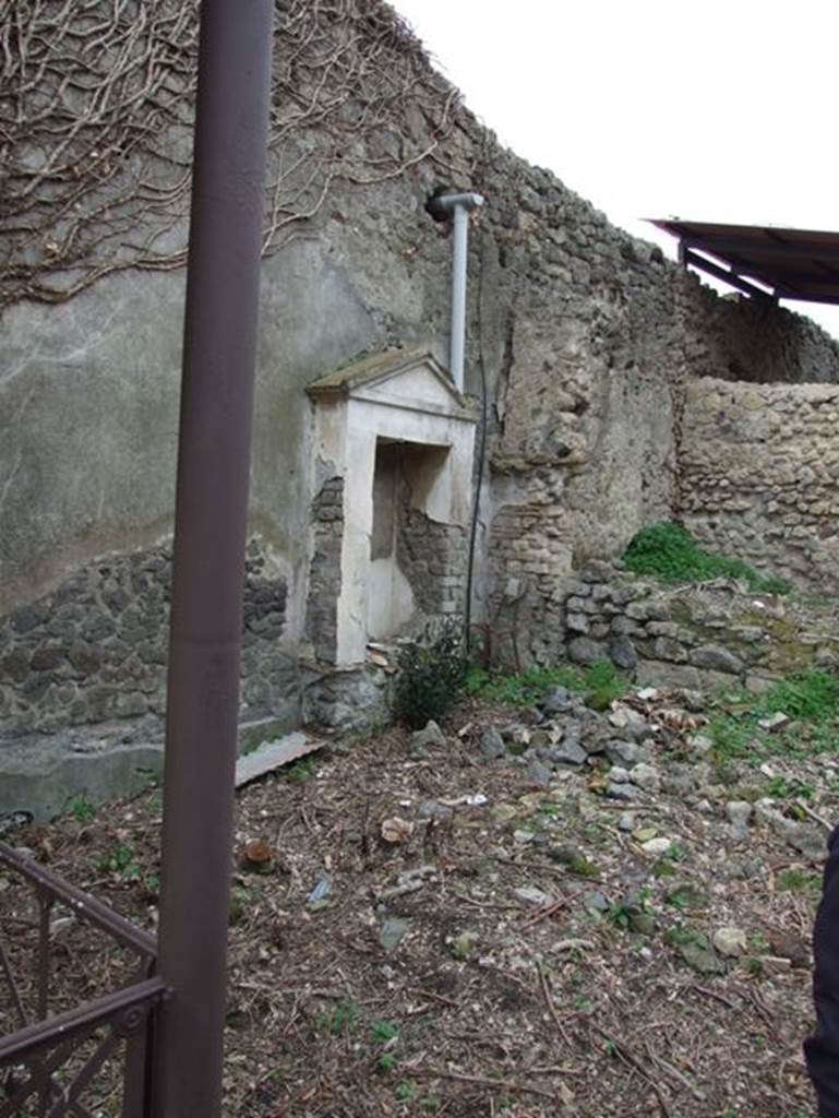 IX.7.20 Pompeii. December 2007. Aedicula with niche on north side of fountain.
According to Boyce –
In the centre of the west wall of the garden is a fine mosaic fountain and on each side of it a simple aedicula (h.3.0), consisting of a rectangular niche (h.1.52, w.0.81, d.0.51) enclosed by walls built on the top of the rectangular podium (1.40 by 0.32, h.0.80).
The opening of the niche is framed by two pilasters which seem to support the simple architrave and pediment above them.
The base is coated with red stucco, the upper part of the structure with white, including the interior of the niche, the back wall of which is outlined in green.
Within the niche on the right of the fountain were found five terracotta statuettes.
He quotes references – Not. Scavi, 1881, 24; Bull. Inst., 1883, 154.
See Boyce G. K., 1937. Corpus of the Lararia of Pompeii. Rome: MAAR 14. (p.89, no. 446).
