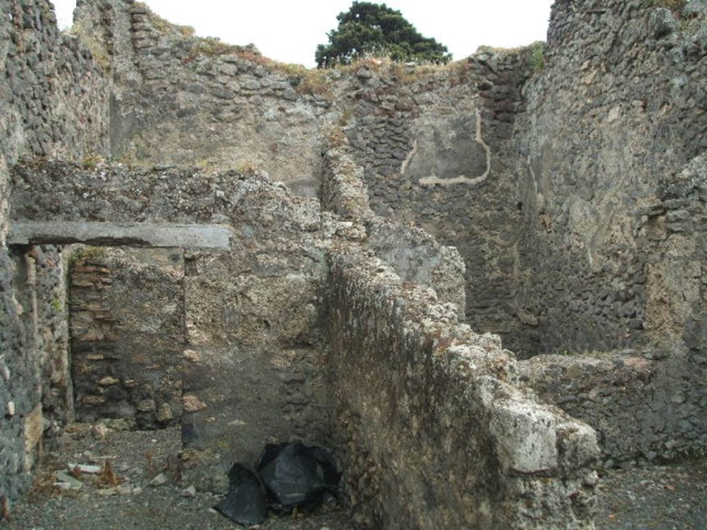 IX.9.9 Pompeii. May 2005. Looking south from corridor, towards doorway to light-yard (seen on upper right side). Through the doorway on the left, was an open courtyard garden area at the south of the corridor. At the rear of the doorway (on upper left-side) would be another room with a doorway from the open courtyard and with window into the courtyard on its west side. According to Eschebach, on the right was a kitchen with a window to the light-yard. At the rear was a windowed triclinium, and a courtyard garden.
See Eschebach, L., 1993. Gebäudeverzeichnis und Stadtplan der antiken Stadt Pompeji. Köln: Böhlau. (p.442)
According to NdS, the room on the right would have been a narrow storeroom. The room in the upper left-rear side was a “mystery” room (stanza mistica) with a projecting window into the courtyard. In the courtyard was the doorway to the “mystery” room, on its external wall was seen the remains of a painting of a large serpent. In its north-west corner, and bricked into the pilaster, was a terracotta tub or basin ?
See Notizie degli Scavi, 1889, p.526

