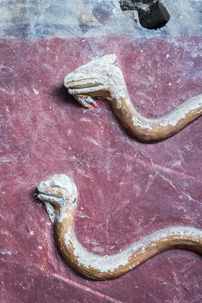 IX.10.1, Pompeii. July 2024. 
Room 12, detail of stucco serpents from centre of upper south wall. Photo courtesy of Johannes Eber.
