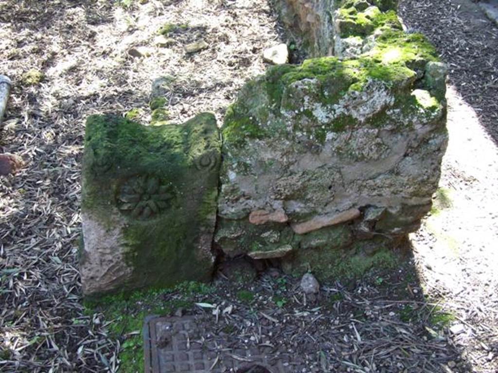 I.12.8 Pompeii.  March 2009. Room 9. Peristyle garden. Low wall separating portico from garden, with decorated stone.