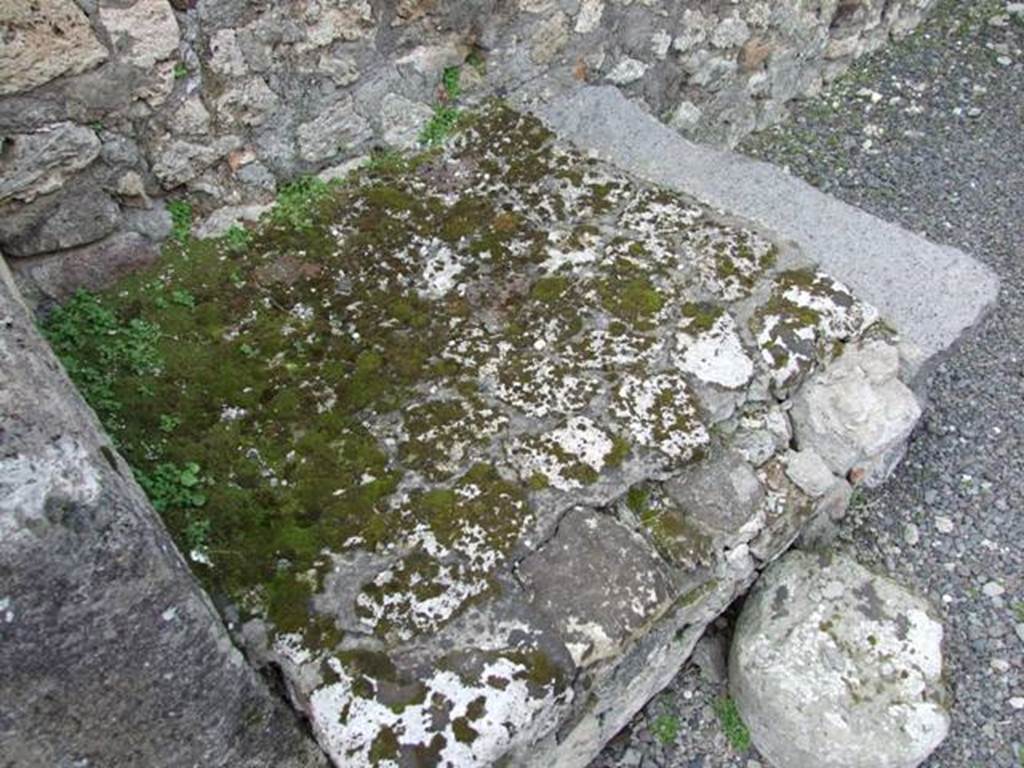 V.2.13 Pompeii. March 2009. South-west corner of thermopolium, and masonry hearth or base. 
According to Boyce, 
“Above the hearth in the south-west corner is a poorly preserved lararium painting: The Genius is represented sacrificing at an altar; on each side originally stood a Lar, only the one on the right being now preserved; further to the right a single serpent approaches an altar.
The above description is taken from Sogliano published in 1879; the descriptions of this house in Rom. Mitt and Not. Scavi, published fifteen and seventeen years later, mention only an altar is visible in a painting, but presumably all refer to the same shrine.”
See Boyce G. K., 1937. Corpus of the Lararia of Pompeii. Rome: MAAR 14, (p.34, no.92).
According to NdS, this thermopolium had a sales counter and a small hearth.
On the west wall Sogliano could see the remains of a painted lararium, with a serpent sliding towards an altar on the left.
At the rear was located the room for the customers, which was bordered by a corridor to the latrine.
See Notizie degli Scavi di Antichità, 1896, (p.438)

