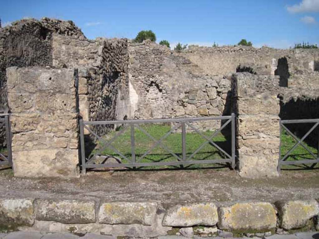 I.2.7 Pompeii. September 2010. Looking east to entrance doorway from Via Stabiana.
Photo courtesy of Drew Baker. According to Warscher, quoting Fiorelli, I.2.7  Questa spaziosa bottega, che stando in communicazione con la seguente, aveva pure in fondo un locale illuminato da ampia finestra, tiene sulla destra parete graffita unepistola, da cui pu trarsi con probabilit il nome del padrone del luogo, (CIL IV. 3905, see below).
See Warscher T., 1935. Codex Topographicus Pompeianus: Regio I.2. (after no.19 f), Rome: DAIR, whose copyright it remains.
(translation: I. 2.7  "this spacious shop, that was in communication with the following, had a room at the rear lit by a large window, found on the right wall an epistle graffito, from which could be drawn with probability the name of the owner of the place, (CIL IV. 3905, see below).