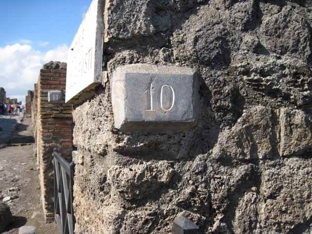 I.2.10 Pompeii. September 2010. ID number plate on north side of entrance, and looking north along Via Stabiana. Photo courtesy of Drew Baker.
