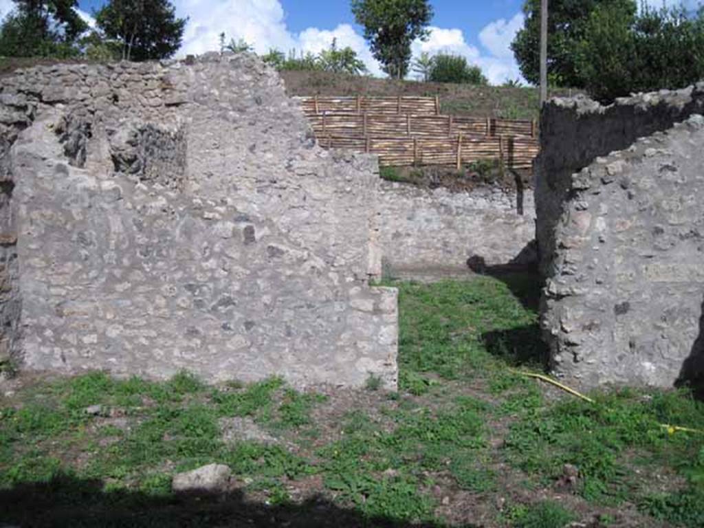 I.2.22 Pompeii. September 2010. Room 5, garden area. Looking east to doorway to shop-room, and across to entrance doorway. Photo courtesy of Drew Baker.
