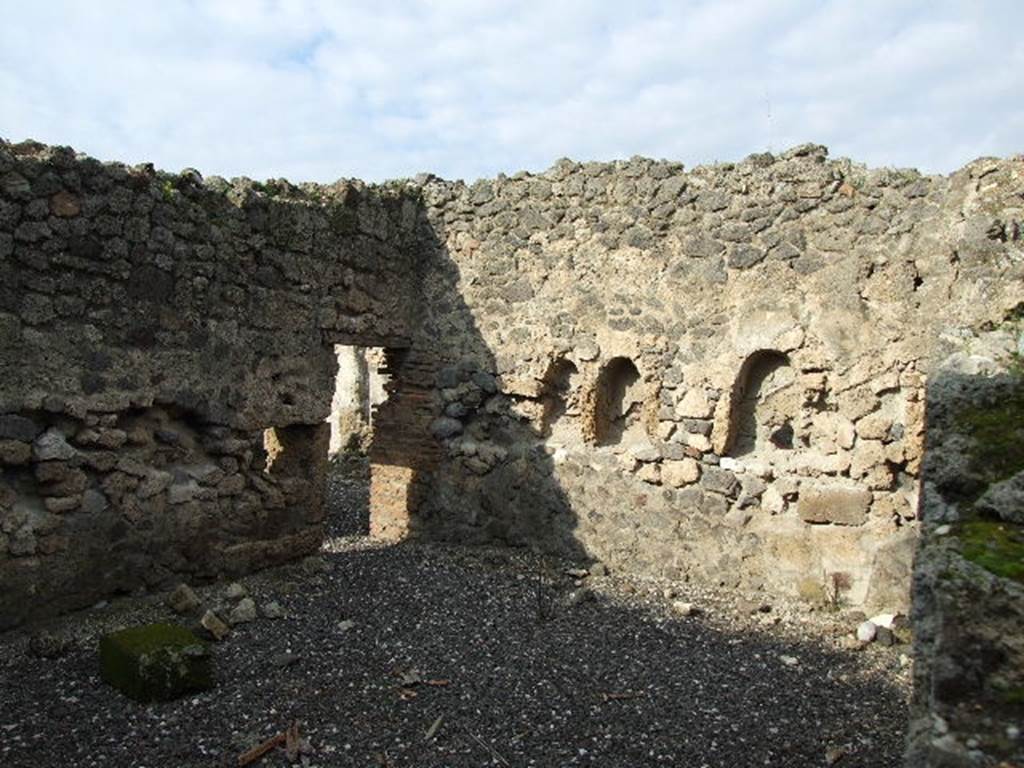 I.3.8b Pompeii. December 2006. North-west corner of kitchen on east side, through hole in wall from I.3.25. According to Boyce, two arched niches were found on the north wall of the kitchen. The niches were 0.58 high and 0.36 wide, 0.30 deep and 1.10 above the floor.
The niches were side by side, and 0.60 apart. He said Fiorelli described them as nicchie per i domestici Lari.
See Boyce G. K., 1937. Corpus of the Lararia of Pompeii. Rome: MAAR 14. (p. 24)

