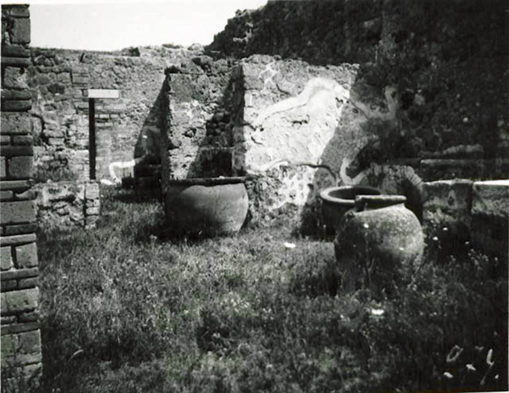 10502-warscher-codex-115-640.jpg
I.5.2 Pompeii. 1936, taken by Tatiana Warscher. Looking towards the north-east corner of the peristyle. The dolia were necessary for the occupation. The podium for the lararium can be seen, centre left, near the brick wall.
See Warscher T., 1936. Codex Topographicus Pompeianus: Regio I.1, I.5. (no.26c), Rome: DAIR, whose copyright it remains.
