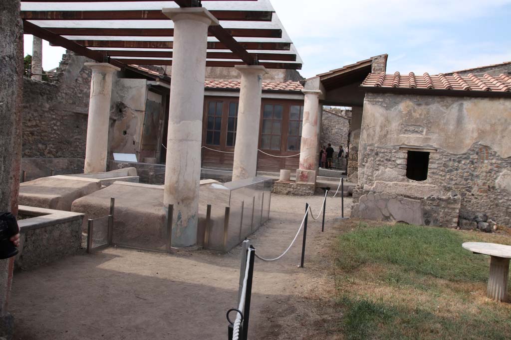 I.7.12 Pompeii. September 2021. 
Looking north-west across garden area with summer triclinium towards north portico. Photo courtesy of Klaus Heese.
This photograph was taken from the doorway into I.7.19, a house linked to this one and photographed below.
The photographs commence on the west side of the insula, from the entrance doorway in Vicolo di Paquius Proculus, and returning to this area.


