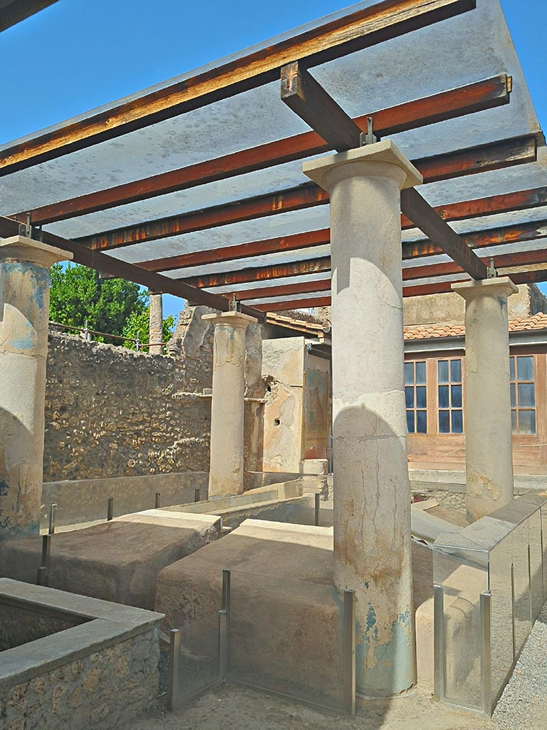 I.7.12 Pompeii. September 2024.
Looking north-west across triclinium in garden towards west wall and north portico.  
Photo courtesy of Giuseppe Ciaramella.
