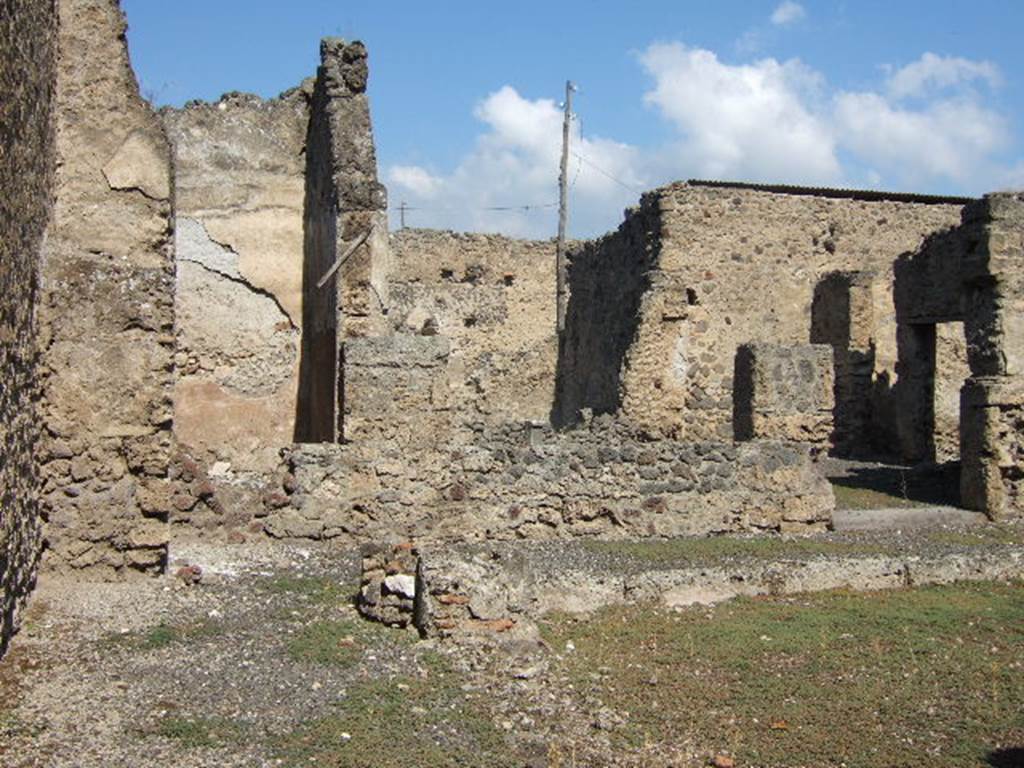 I.8.13 Pompeii. September 2005. Looking north from entrance, along west side of courtyard. According to Jashemski, this entrance led directly into a covered passageway. This passageway enclosed the courtyard at the front of the house, on the west and north side. 
In the north-west corner of the passageway, there was a large lararium. See Jashemski, W. F., 1993. The Gardens of Pompeii, Volume II: Appendices. New York: Caratzas. (p.43)  According to Della Corte, found written on the lararium were the names of two, perhaps dependants or family of Granio – Diadumenus (and) [D]iopha[ntus]    [CIL IV 7296]   See Della Corte, M., 1965.  Case ed Abitanti di Pompei. Napoli: Fausto Fiorentino. (p.327)
According to Epigraphik-Datenbank Clauss/Slaby (See www.manfredclauss.de), these read as -
Diadumenus 
[3]vac 
[                                 [CIL IV 7296a] 
] Saltus 
Diopha[ntus(?)]     [CIL IV 7296b]

