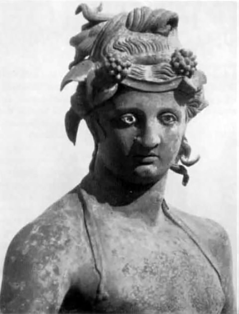 I.16.2, Pompeii. Detail of bronze statue of a young Bacchus.
See Elia, O., 1961. Bacco Fanciullo e Dioniso Chtonio a Pompei: Bollettino dArte 1961, Fasc. I-II, (p.2, fig.2). 
Kuivalainen comments 
This is another young Bacchus looking absentmindedly elsewhere, and not fully occupied with the activity he is engaged in.
He is pouring wine for a panther, and is perhaps intoxicated himself, as indicated by the position of his legs and the left hand, which once held a thyrsus tightly. The hairstyle may be inspired by Isiac counterparts. (489).
(Note 489 reads  Elia 1961, 2  3, suggested that the statue was a product of the eastern provinces).
See Kuivalainen, I., 2021. The Portrayal of Pompeian Bacchus. Commentationes Humanarum Litterarum 140. Helsinki: Finnish Society of Sciences and Letters, (H15, p.220).

