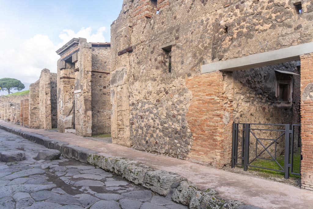 V.1.28 Pompeii. January 2024. 
Looking north on east side of Via del Vesuvio, with entrance doorway, on right. Photo courtesy of Johannes Eber.
