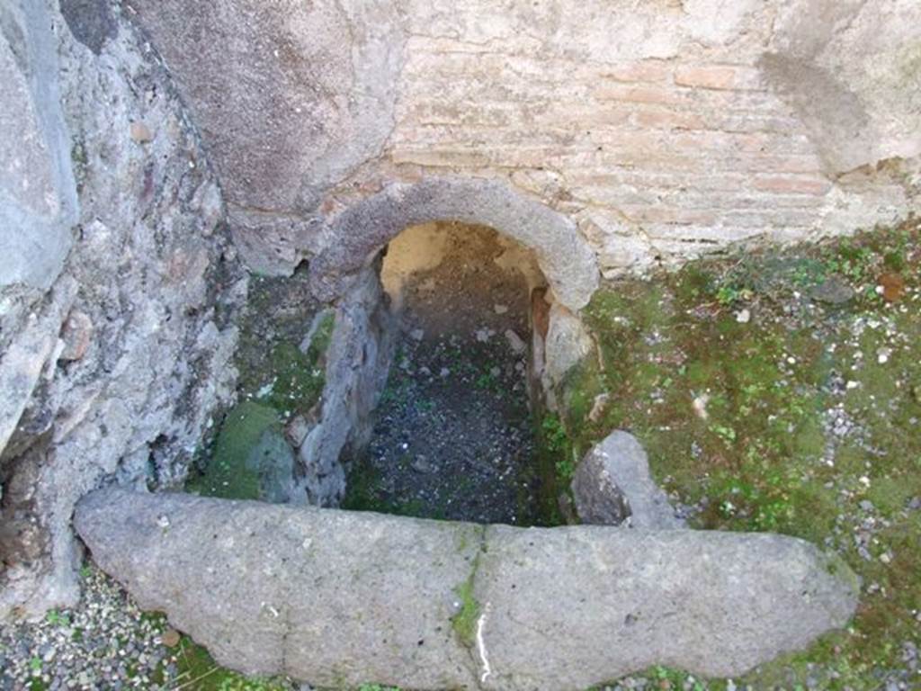 V.2.i Pompeii. December 2007. Room 11, south side of kitchen.  Hole in the floor and wall leading into caldarium.  

