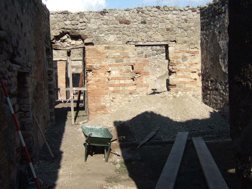 VI.13.16 Pompeii. September 2005. Looking east from corridor in garden area. On the right is the window overlooking the garden area.
According to Jashemski, the small garden excavated in 1874 with a covered passageway on the east and north sides.
It was located at the rear of house 16 and communicated with the caupona that had its entrance at 17.
At the rear of the atrium, instead of the usual tablinum, there was a wide windowed room, which looked out onto the garden.
The garden may have been used to serve guests patronizing the caupona.
See Jashemski, W. F., 1993. The Gardens of Pompeii, Volume II: Appendices. New York: Caratzas. (p.148)
