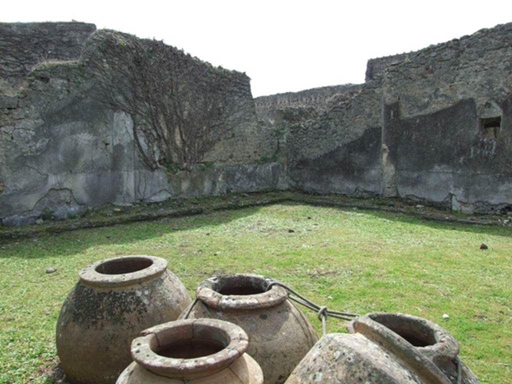 VI.16.27 Pompeii. March 2009. Looking south-west across peristyle garden M. According to NdS, in the north-east corner of the garden area was a group of terracotta pots, fixed into the soil. They consisted on three large spherical dolii, two others somewhat smaller with cylindrical bodies of the type seen in the sales counters of thermopolii, the sixth was of the same type but very much smaller. Two of the three large earthenware jars were broken and had been reattached with lead by the ancients. The third of the large dolii, had a number incised onto its belly – XVII. See Notizie degli Scavi, 1908, (p.190)
