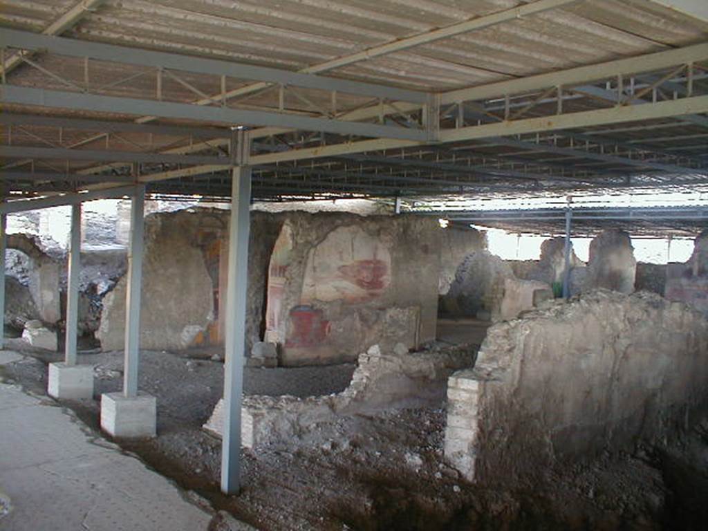 VI.17.41 Pompeii. September 2004. Looking north-east from rear of house towards north wall of tablinum. According to PPM, this room has been very badly preserved, it was damaged during the Bourbon excavations when the south wall of the neighbouring room was cut away, and was possibly deprived of its mosaic floor at that time. On the north wall, the only wall that retains any decoration, the zoccolo was red and in it, in the centre of the wall a female figure can be seen. In the middle area of the wall, resting his right foot on the base of a podium was a huge figure and nearby the bow of a ship. The zoccolo appeared to be more sunken into the wall than the rest of the wall, and with its sharp break from the painting of the middle area, may have been of a previous wall decoration.
