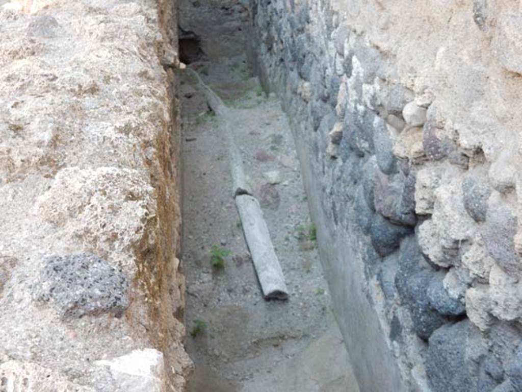 VII.1.17 Pompeii. May 2017. Lead pipe in narrow passage on south side of room 21 of VII.1.47.
The rear wall is probably shared with VI.1.17 and the pipe joining with that in VII.1.17.
Photo courtesy of Buzz Ferebee.

