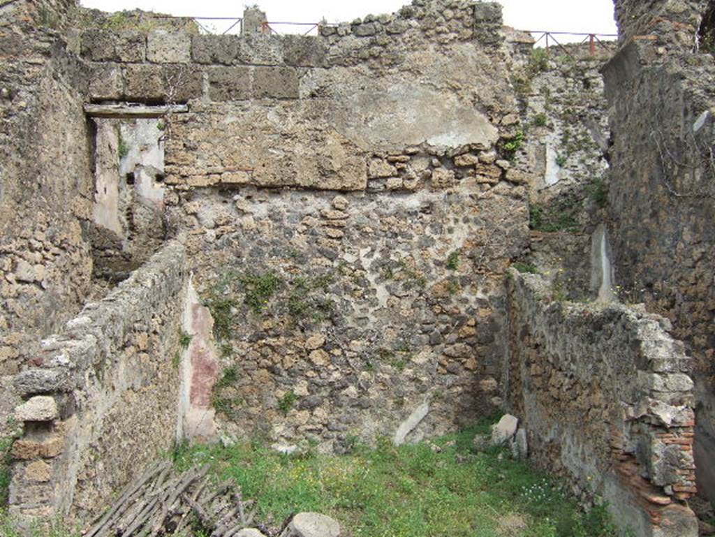 VIII.2.34 Pompeii. May 2006. Room ‘8’, looking north across middle triclinium on lower level.
The walls of this large room, which made up the central residential space of this lower floor, showed a painted black zoccolo, purple panels with blue borders. Mau defined the decoration as of a candelabra on a peacock-blue/purple background. The room was covered with a vaulted ceiling and also two narrow areas to the side, the passageway ‘7’ (on the left) and the narrow area (on the right) perhaps a store-cupboard. In the rear wall of the store-cupboard was a window opening into the corridor ‘5’. The cocciopesto floor had polychrome ‘crustae’, and a threshold of well-executed white meander tesserae, which separated this from its anteroom.
