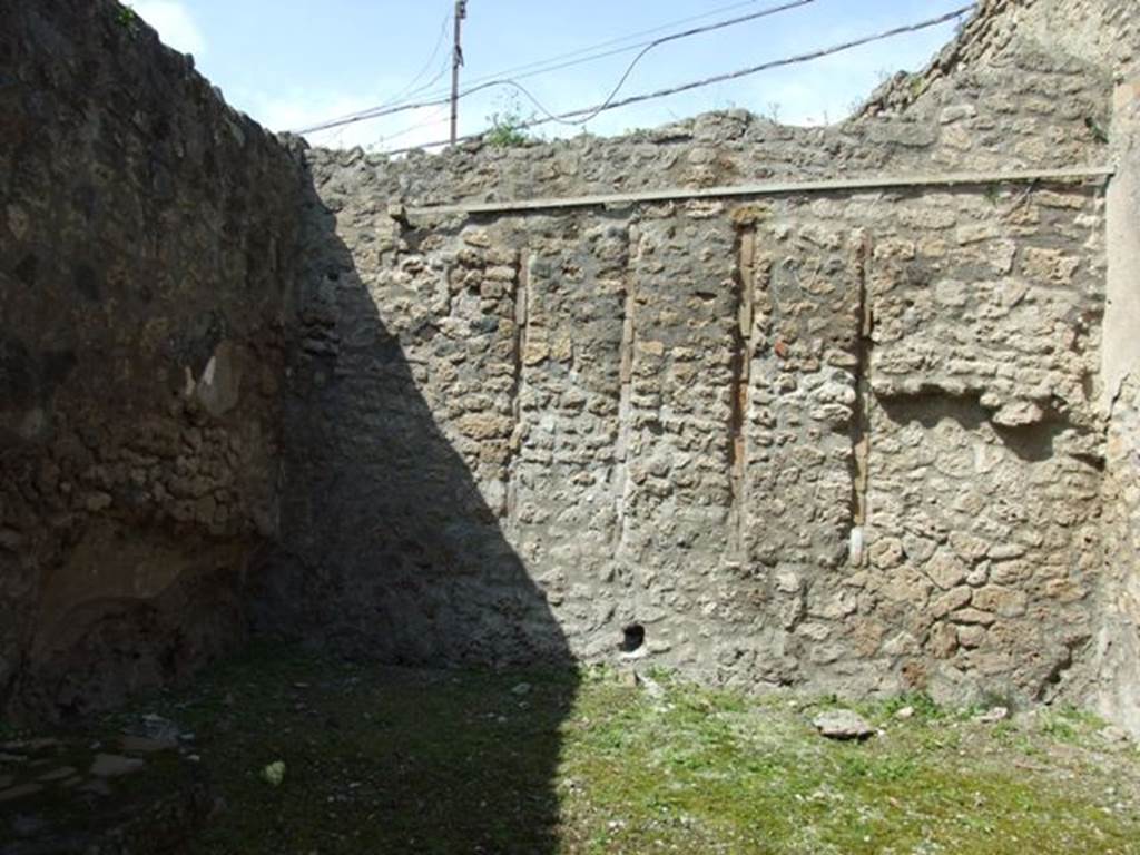 IX.1.27 Pompeii. March 2009. North wall.
According to Warscher  
In the north wall are three narrow vertical strips that mark the place where wooden planks were embedded into the wall, perhaps for the purpose of reinforcing the stucco. No satisfactory explanation has been given so far.
She also quotes similar examples at VI.11.10, and VII.2.6.  
See Warscher, T. Codex Topographicus Pompeianus, IX.1. (1943), Swedish Institute, Rome. (no.143), p. 249.
