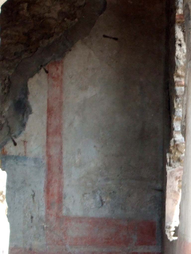 IX.2.7 Pompeii. May 2006.Painted wall in triclinium (k) showing the south end of the east wall.
The red zoccolo showed a panel with oval-leafed plants and compartments with a hanging disc under the separating cornice of the middle zone.
The middle zone presented a white panel, with wide yellow border and a painting of a trophy vase.
The south wall had a window overlooking the garden area.
It was in the centre of the wall between the two white side panels, in which were paintings of trophy vases (13 x 22 - vasi agonistici), now illegible.
The zoccolo was red.
On the west wall, to the north of the doorway, with a yellow central panel and a white predella below it, was a painting with Leda, now illegible. (see Helbig 143).
On the north wall, in the central panel, was a painting of Achilles at Skyros, but preserved only in the upper right corner. (See Helbig 1302).
See Bragantini, de Vos, Badoni, 1986. Pitture e Pavimenti di Pompei, Parte 3. Rome: ICCD. (p.409)
See Helbig, W., 1868. Wandgemlde der vom Vesuv verschtteten Stdte Campaniens. Leipzig: Breitkopf und Hrtel. (143 and 1302)
