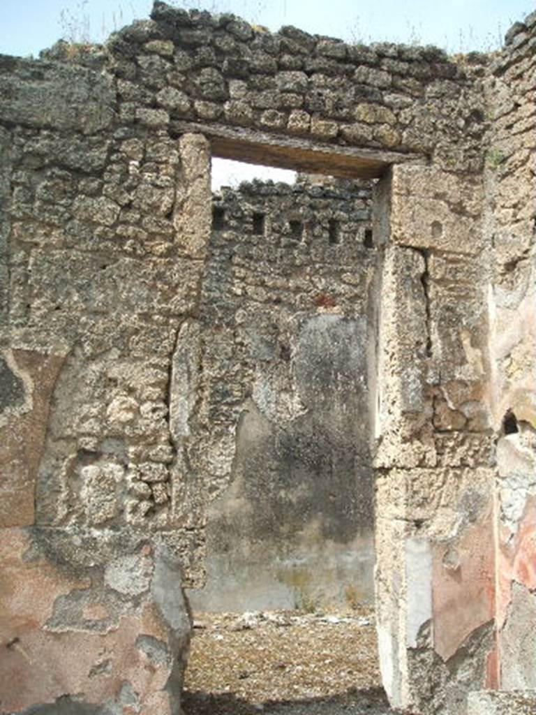 IX.6.5 Pompeii. May 2005. Doorway to room “d”, originally the north ala.
According to Mau, this room had a simple decoration on its walls in a style that was difficult to attribute to the III or IV style of decorative painting. 
See Mau in BdI, 1880,  (p.227-8)
A statuette of white marble Pigmy was found in room “d”, on 24/10/1878. 
Now in Naples Archaeological Museum.  Inventory number 120406.
See Marmora Pompeiana nel Museo Archeologico Nazionale di Napoli: Studi della SAP 26, p. 178.
