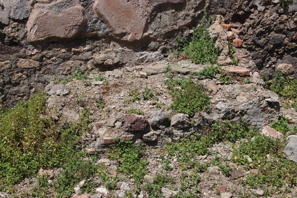 IX.6.7 Pompeii. May 2024. Detail of hearth leaning against north wall of kitchen. Photo courtesy of Klaus Heese.