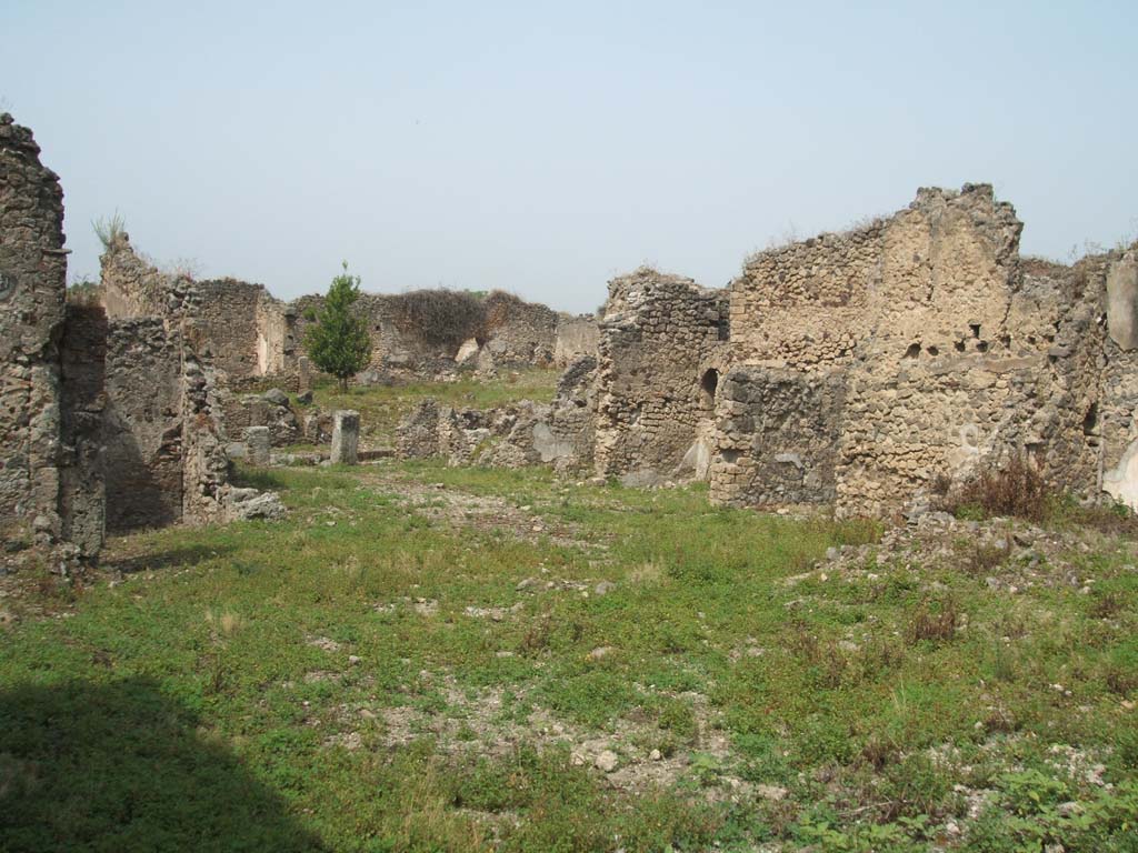 IX.6.g Pompeii. May 2005. North-west corner of peristyle, looking west towards remains of IX.6.4.
The room on the extreme right of the photo, may be the room (in IX.6.g) with the niche as described by Boyce.
See Boyce G. K., 1937. Corpus of the Lararia of Pompeii. Rome: MAAR 14. (p. 87, no.435 and Pl.3, 6) 
