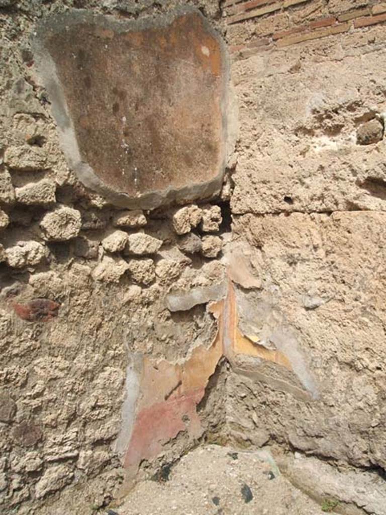 IX.7.21/22 Pompeii. May 2005. 
Remains of painted plaster in the north-west corner of the room on east side of caupona.

