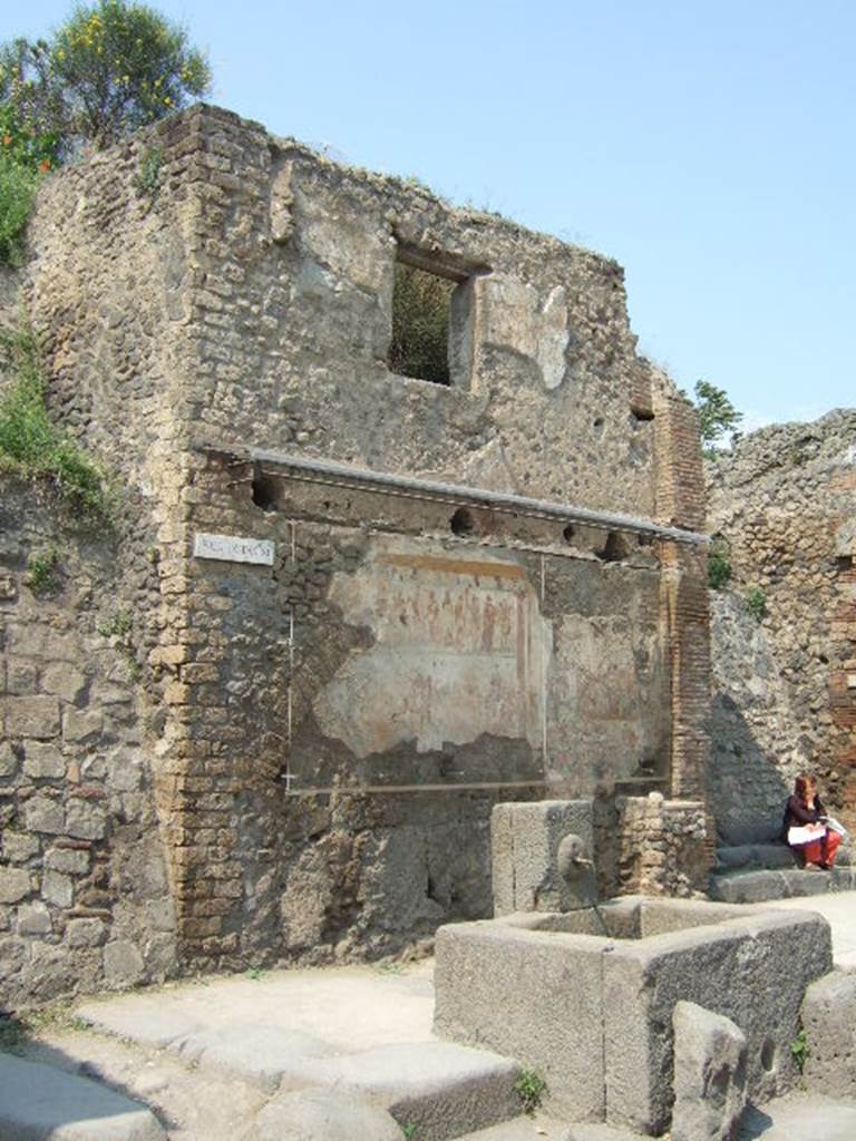 IX.11.1 Pompeii. May 2006. Front faade of house on west side of entrance doorway, with steps. House with street shrine and fountain outside.
