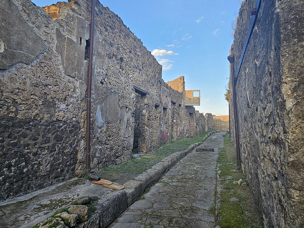 Vicolo del Gallo, Pompeii November 2024. 
Looking east along vicolo between VII.15 on left, and VII.7 on right, from outside of VII.15.2. Photo courtesy of Annette Haug.
