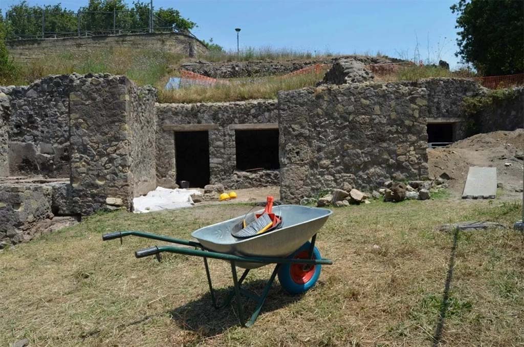 HGE20 Pompeii. June 2016. The shop where the five fugitives had taken refuge.
Here the archaeologists, while emptying the rooms of a workshop already explored in the nineteenth century by Giuseppe Fiorelli, came across a layer untouched by the nineteenth-century excavators and found the skeletons of five fugitives, who had found refuge in the workshop while trying to escape the fury of the eruption of Vesuvius in 79 AD: Alongside the bones, three gold coins, a necklace pendant and some tableware were found, mixed together after the looting by clandestine diggers who ventured into the workshop after the eruption of 79 AD. They had ventured into the city in search of treasures buried under the ashes. The area was damaged by bombing in 1943.

La bottega dove si erano rifugiati i cinque fuggiaschi.
Qui gli archeologi, mentre svuotavano gli ambienti di una bottega già esplorata nell'Ottocento da Giuseppe Fiorelli, si sono imbattuti uno strato non intaccata dagli scavatori ottocenteschi e hanno rinvenuto gli scheletri di 5 fuggiaschi, che avevano trovato rifugio nella bottega mentre cercavano si sfuggire alla furia dell'eruzione del Vesuvio del 79 dopo Cristo: accanto alle ossa sono state ritrovate tre monete d’oro, un pendente di collana e alcuni vasi da mensa, mescolati alla rinfusa dopo i saccheggi degli scavatori clandestini che dopo l’eruzione del 79 d.C. si avventurarono nella città alla ricerca di tesori sepolti sotto la cenere. La zona fu danneggiata dal bombardamento del 1943. 

Photograph © Parco Archeologico di Pompei.
