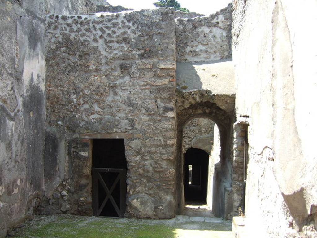 HGW24 Pompeii. May 2006. Looking west through square hole in wall, on south side of entrance at HGW25.
The doorway on the right, would lead to the “wagon’s entrance” in the side entrance. 
