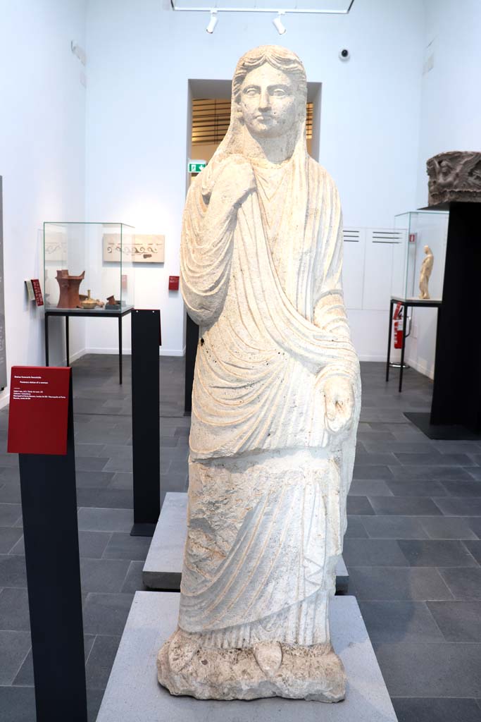 Porta Nocera tombs 34aEN. February 2021. 
Limestone funerary statue of a woman, on display in Antiquarium.
Photo courtesy of Fabien Bièvre-Perrin (CC BY-NC-SA).
