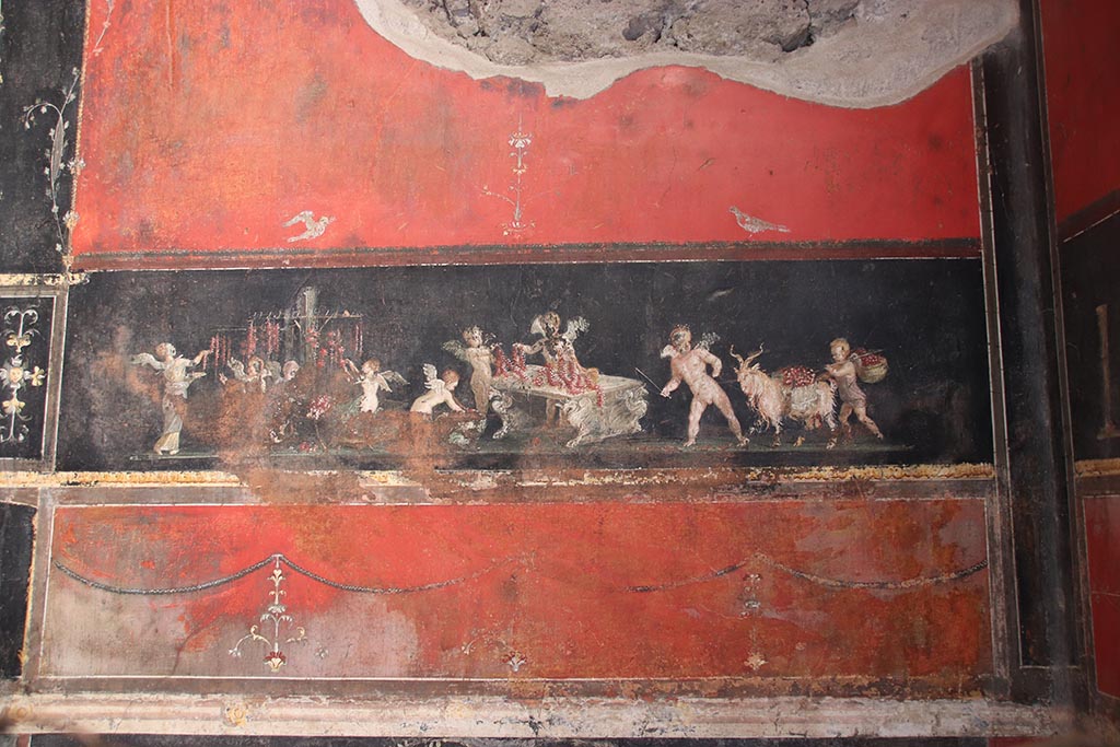 VI.15.1 Pompeii. October 2024. 
East wall in the south-east corner with painting of cupids as flower dealers, picking and selling flowers and making garlands.
Photo courtesy of Klaus Heese
