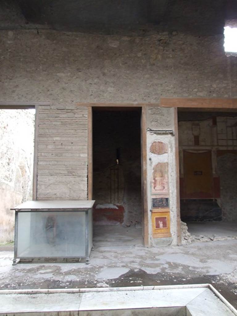 VI.15.1 Pompeii. December 2006. Looking south across atrium, towards glass case.  
This contained an iron and bronze strongbox or safe. This was being restored as at December 2006.
According to Della Corte, found in the inside of the house were two bronze seals and a bronze finger ring:
A. Vettius Restitutus   (S.100 on page 470)
A. Vettius Conviva       (S.98 on page 470)
A. V(ettius) Co(nviva)  (S.99 on page 470)
See Della Corte, M., 1965.  Case ed Abitanti di Pompei. Napoli: Fausto Fiorentino. (p.67)
According to NdS, on 10th December 1894, the strongbox was found in fragments, on the left side of the impluvium. It was then reconstructed. On 11th December 1894,  near the strongbox, two bronze seals were discovered.

