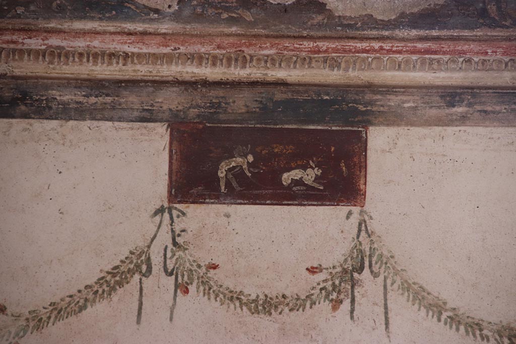 VI.15.1 Pompeii. October 2024. Painted panel from east wall at north end, above medallion. Photo courtesy of Klaus Heese.