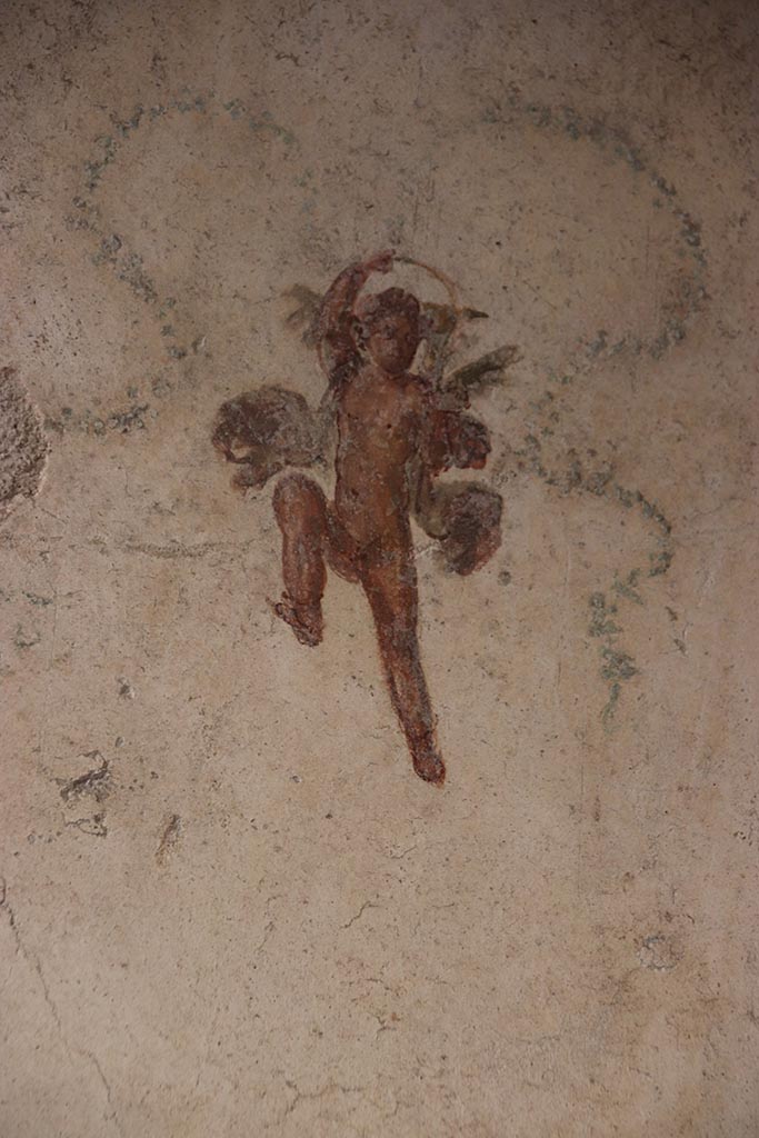 VI.15.1 Pompeii. October 2024. 
Room (f), painted cupid on east wall at south end. Photo courtesy of Klaus Heese.
