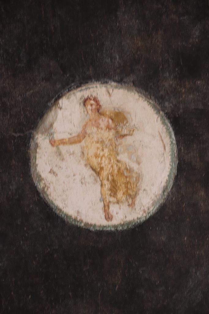 VI.15.1 Pompeii. October 2024.
Triclinium “t”, detail of painted figure in medallion at the east end of the south wall. 
Photo courtesy of Klaus Heese.
