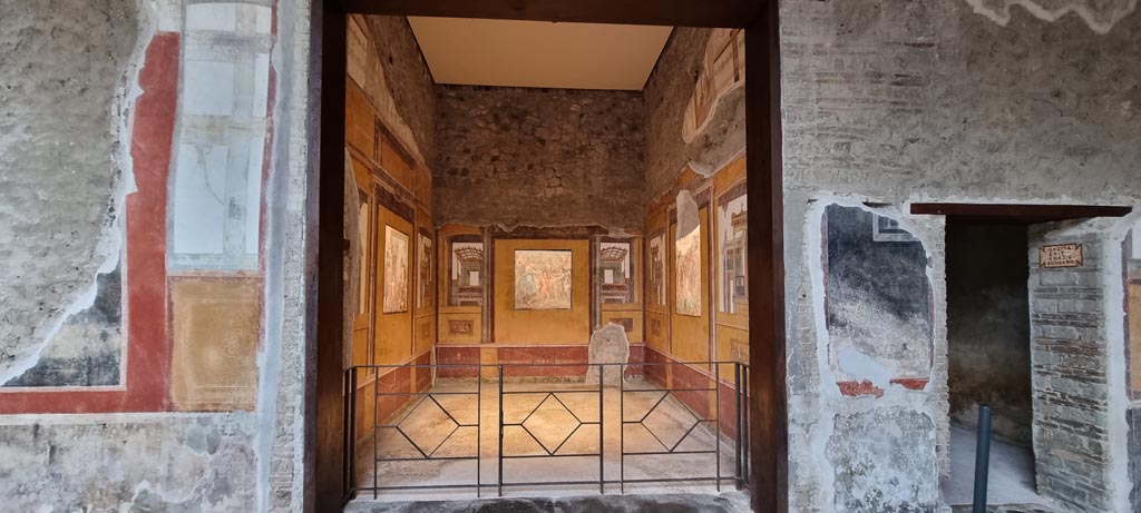 VI.15.1 Pompeii. January 2023. 
East wall in south-east corner of peristyle with doorway to exedra, in centre, and into room o, on right. Photo courtesy of Miriam Colomer.


