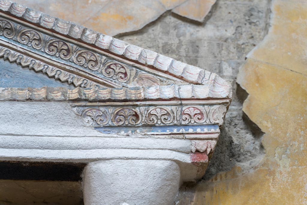 VI.15.1 Pompeii. March 2023. 
Detail of stucco decoration on north end of aedicula against west wall in services area. Photo courtesy of Johannes Eber.
