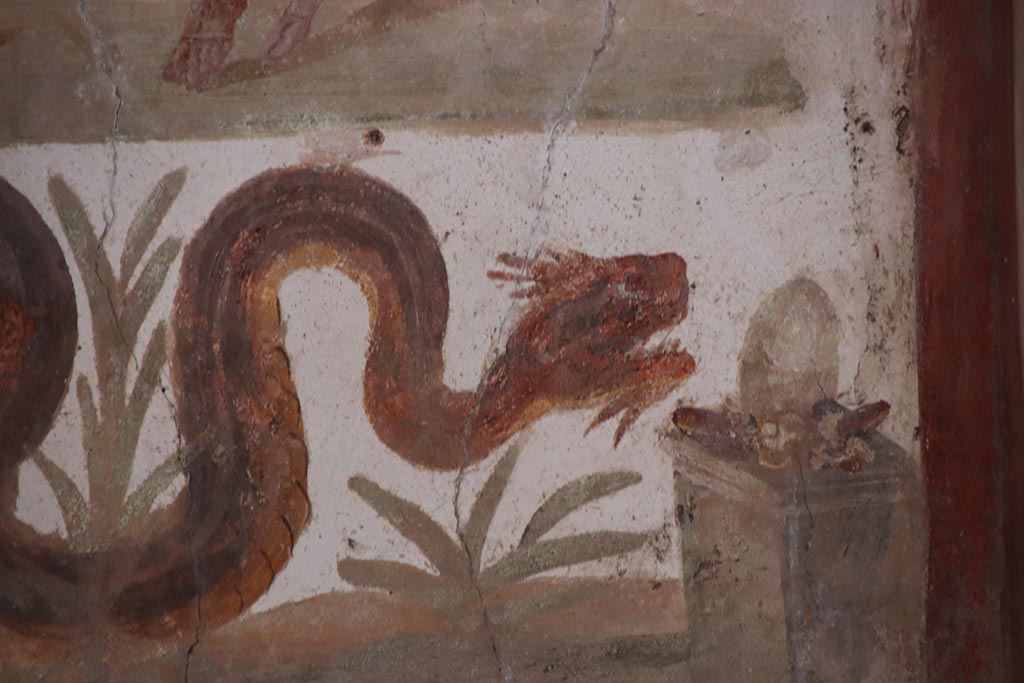 VI.15.1 Pompeii. October 2024. 
Detail of serpent on lararium painting gliding through plants towards altar. Photo courtesy of Klaus Heese.
